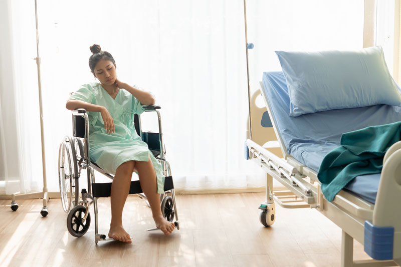 Serious patient sitting on wheelchair in hospital ward